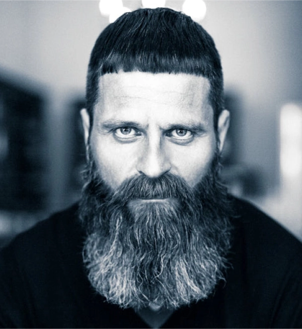 Man with a thick, healthy beard demonstrating a care tip for shine and healthy appearance using Shave & Beard Oil.